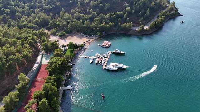 4K drone video of jet ski sailing from the beach towards the bay. Departure from the peninsula towards Fethiye Bay

