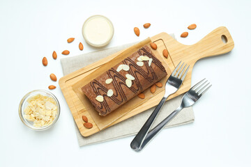 Cake roll with nuts on a wooden board