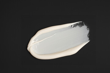 검은 바탕에 묻힌, 문지른 하얀색 크림 화장품