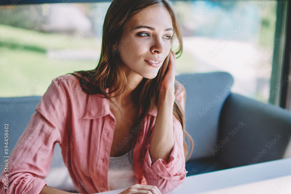 Poster thoughtful female graphic designer looking out of window while updating profile on modern laptop usi