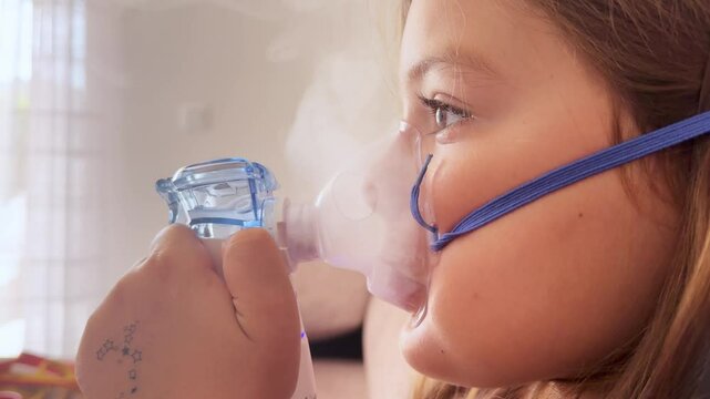 6 years old girl with nebuliser breathing medications. Close-up treatment of Adenoiditis, asthma, cough 