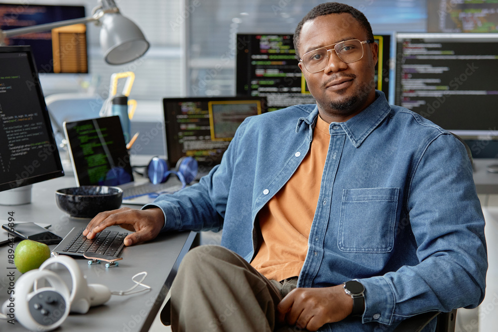 Poster portrait shot of confident male african american vr developer posing while sitting at working desk l