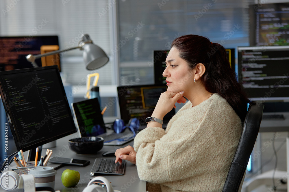 Aufkleber side view shot of thoughtful female middle eastern reviewing code fixing errors while sitting at wor