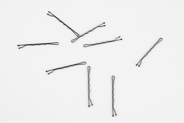 Black metal hair clips on white background