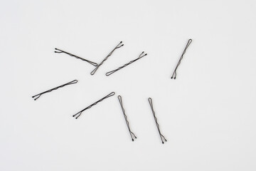 Black metal hair clips on white background