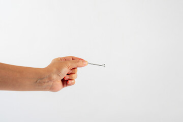 Black metal hair clips in hand on white background