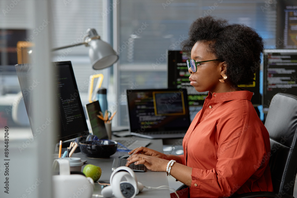 Poster side view shot of thoughtful female african american vr programmer in glasses writing code on comput
