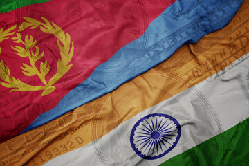 waving colorful flag of india and national flag of eritrea on the dollar money background. finance concept.