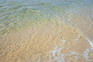 detail view of sea water on the shore of a beach, summer holidays concept
