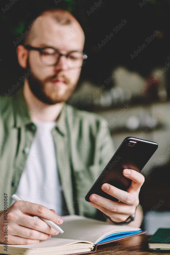Poster selective focus on modern smartphone in hands of bearded young man which searching information on we