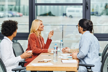 Group of professionals discussing ideas around a table in a contemporary office setting.