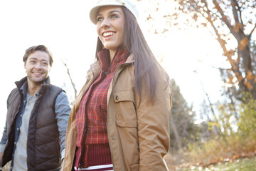 Fototapeta premium Woman, man and walk with nature for park trip, bonding or travel in winter countryside. Smile, love and happy couple in holding hands for morning holiday, vacation or woods picnic or hiking adventure
