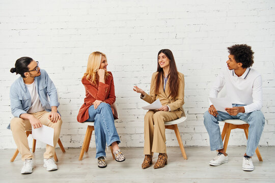 Diverse group engaging in vibrant discussion while seated in chairs.