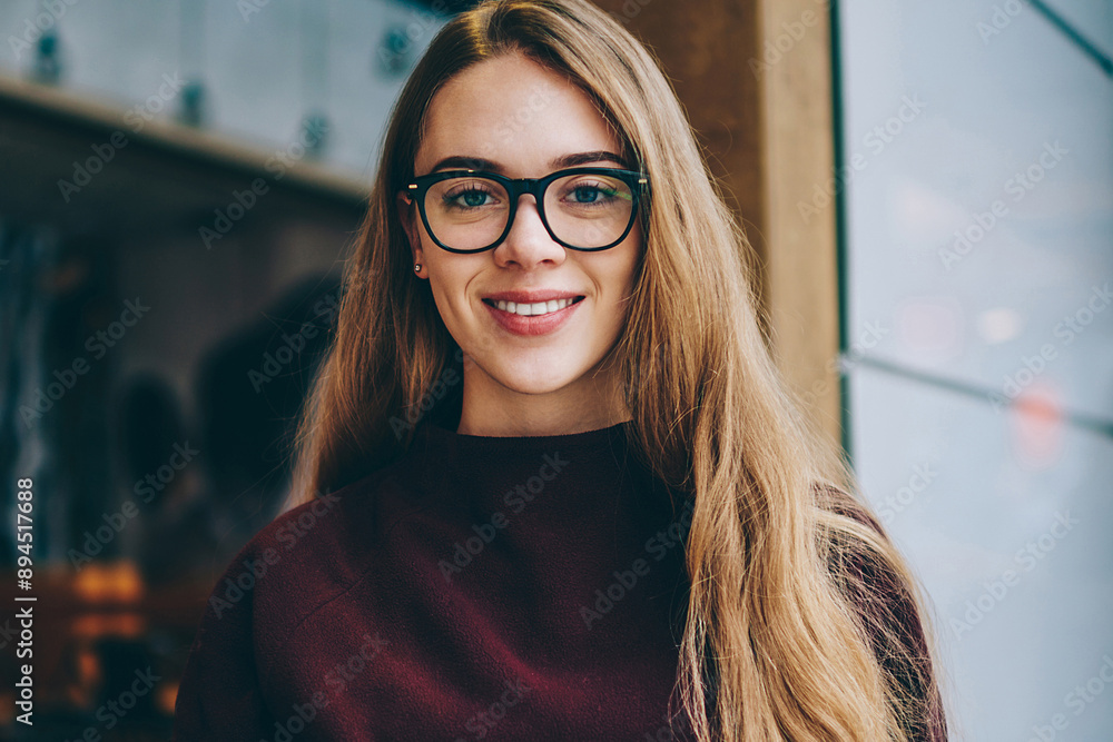 Poster caucasian female student sitting with smartphone and holding open text book in hand while looking to