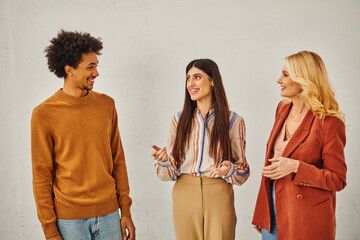 Three individuals engaging in conversation against a blank backdrop.
