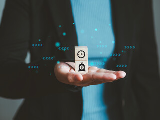 Businessman holds wooden cube with money and time with arrows, business investment