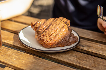 Croissant covered with chocolate. Croissant on plate in cafe or bakery