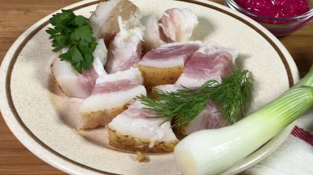 Salted pork fatback slices, bread and seasonings on cutting board
