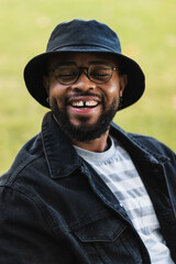 Laughing young man with eyes closed in a park