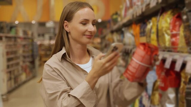 A woman in a beige shirt chooses coffee in a store, scans the label with her smartphone.