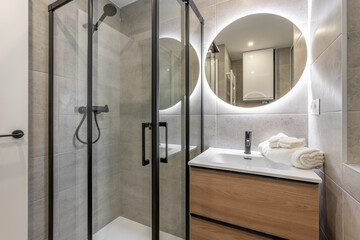 A modern bathroom with a glass shower and backlit mirror for a sleek and elegant look
