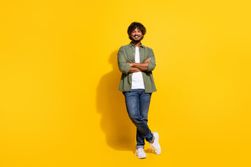 Photo of expert manager mexican confident successful man in khaki shirt and jeans curly haired isolated on yellow color background