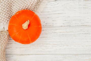 Yellow pumpkin on a gray warm blanket and table, place for text