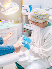 Female podiatrist doing chiropody in her podiatry clinic. Selective focus