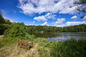 Obraz premium Wooden chairs on the beach of the riverbank