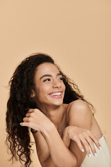 Naklejka premium A young Black woman with curly hair and a bright smile looks off to the side, her natural beauty shining through.