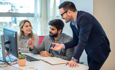 Business professionals collaborating on investments and teamwork, using a computer during a meeting, and working in partnership on the stock market.