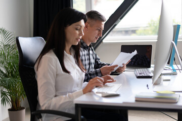 Focused Professionals Working On Documents And Computer In Modern Office