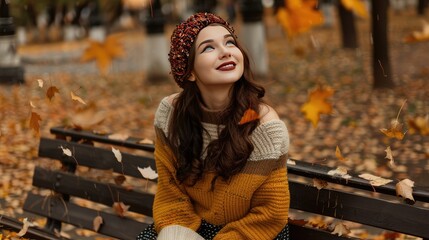 Smiling young woman sitting on park bench in autumn, wearing knit hat