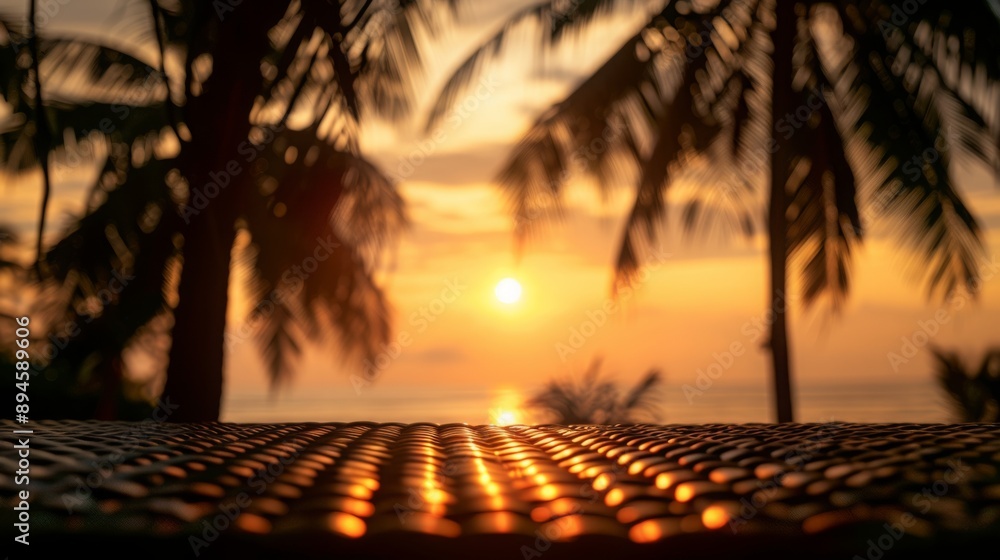 Poster a wicker table sits in front of a beautiful sunset, framed by palm trees.