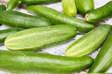 Freshly harvested cucumbers laid out on a rustic wooden table