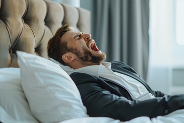 Fototapeta premium Tired Businessman Yawning in Bed