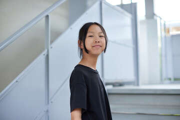 Fototapeta premium 夏の住宅地のマンションの階段を上る一人の小学生の子供の様子