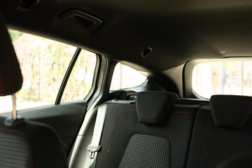 The back seats of a car with red stitching