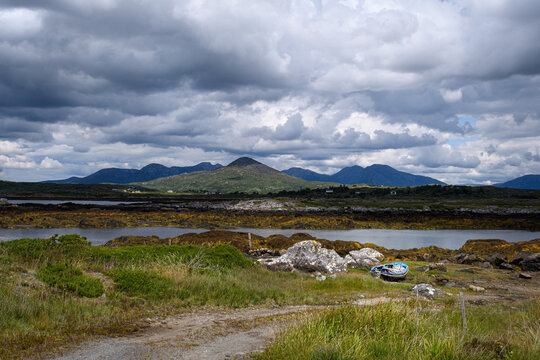 Old boat next to a waterway with a mountain background