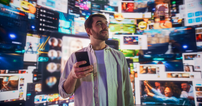 Portrait of Caucasian Man Using Smartphone in Metaverse With Animated Stream Of Interfaces With Social Media, e-Commerce Shopping, Internet Influencers And Games. Visualization Of Web Network.