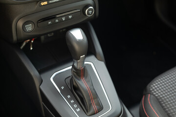 The interior of a car with a black leather gear stick