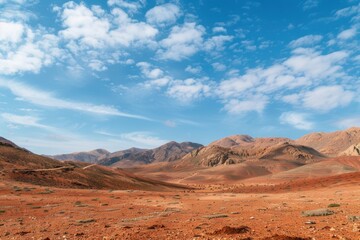Naklejka premium Vast and endless desert mountains under a blue sky with white clouds