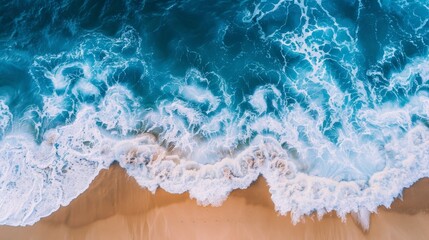 Obraz premium Create an aerial view of a sandy beach and the ocean with waves. Highlight the textures of the sand, the patterns of the waves, and the contrast between the beach and the ocean. Showcase the natural b
