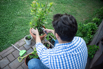 Young man taking care of plants in the garden