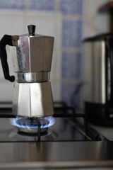 A stovetop espresso pot heats up over a blue flame