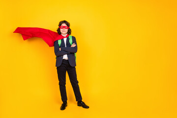 Fototapeta premium Full length photo of small schoolboy crossed hands confident superhero dressed stylish uniform isolated on yellow color background