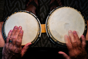 Senior man playing a set of bongo drums 24.07.2024