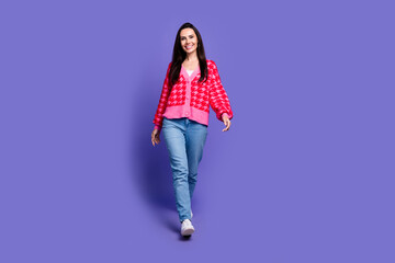 Full length photo of cheerful pretty lady dressed pink cardigan walking empty space isolated violet color background