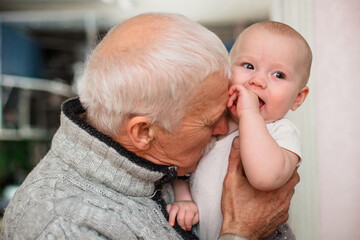Elderly Man Holding and Smiling at Baby