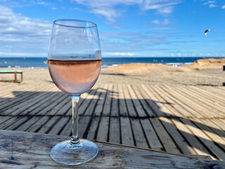 A glass of rose wine against a backdrop of beach, ocean and kitesurfing. A romantic end to the day